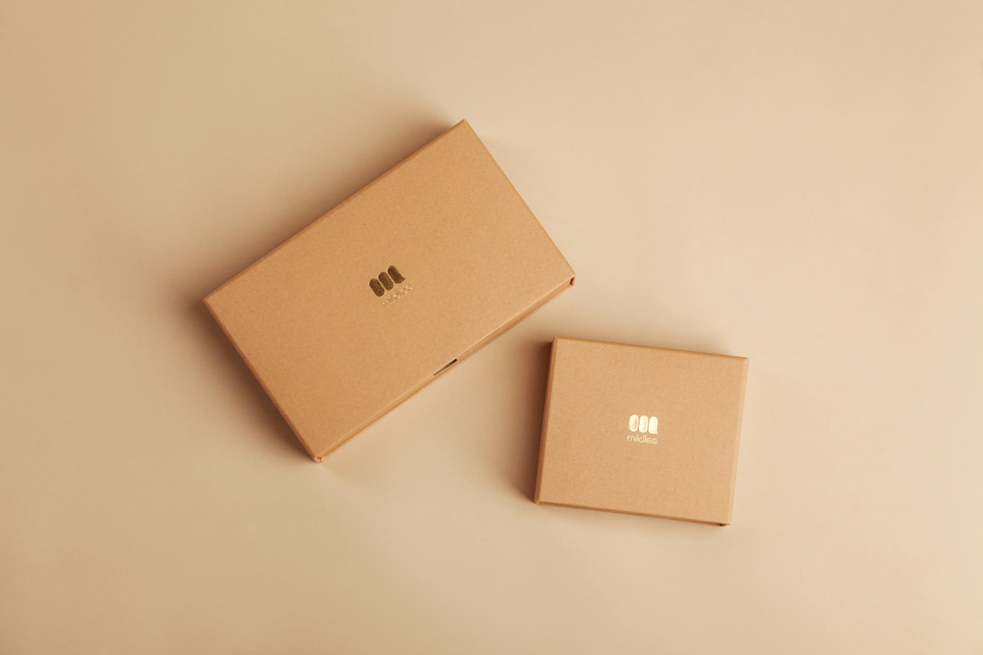 Two plain kraft gift boxes on a warm neutral background