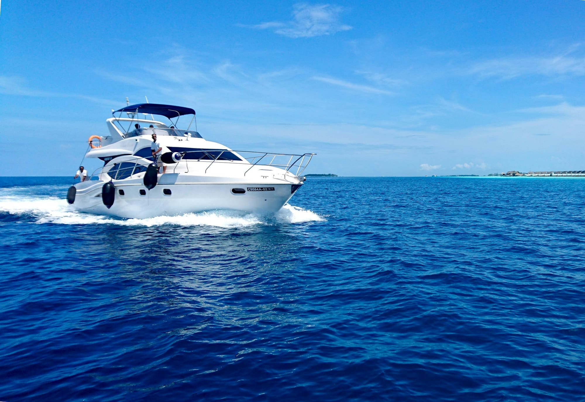 A motor yacht under way, leaving a white wake on a bright day