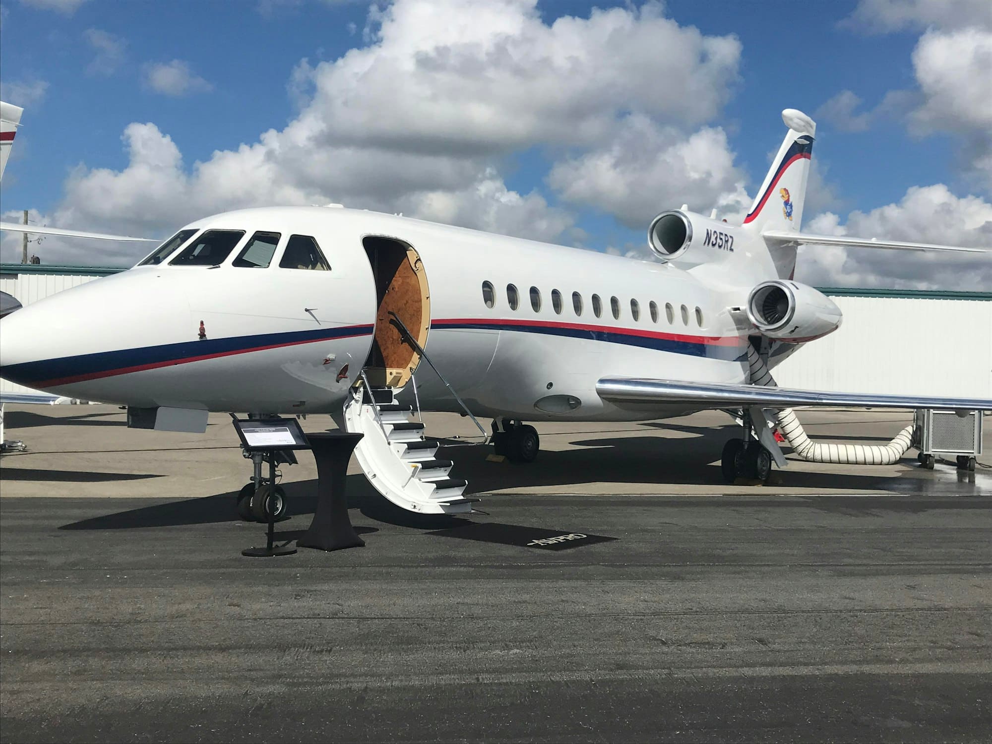 A private jet with its boarding stairs lowered on the apron