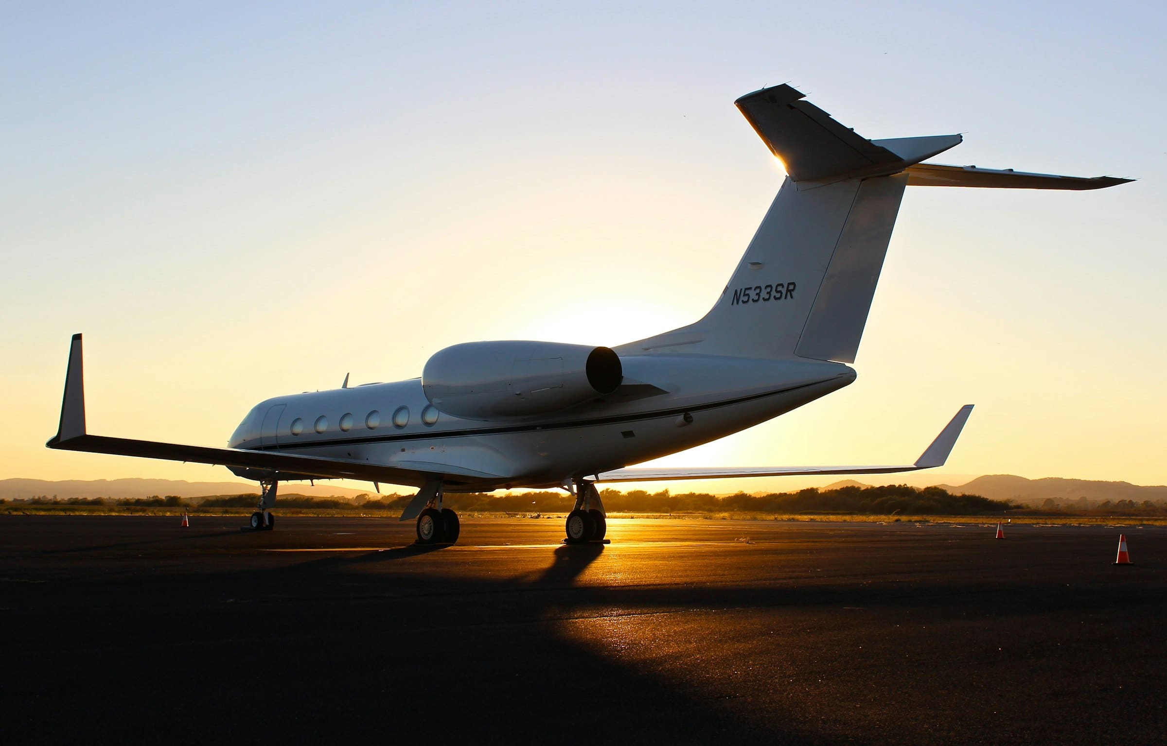A private jet waiting on the tarmac at sunset