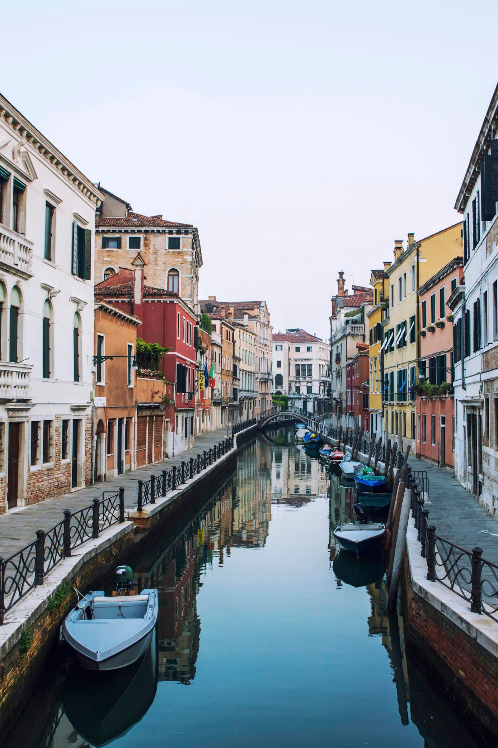 A quiet canal lined with pastel façades and moored boats
